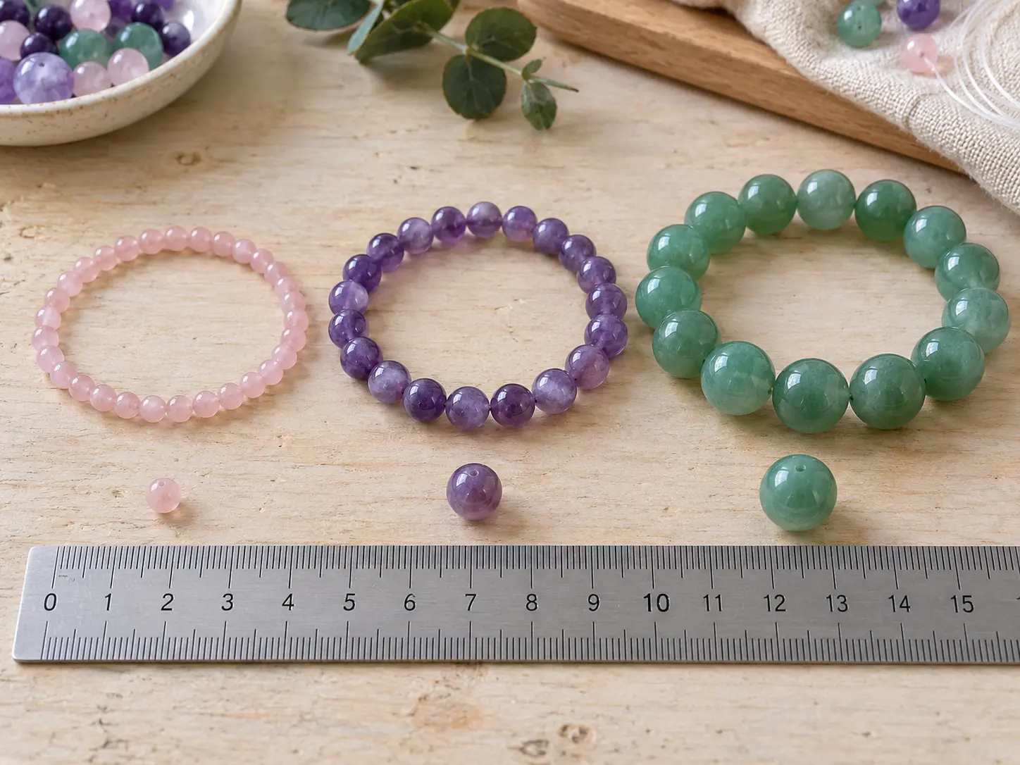 Three finished bracelets in small, medium and large bead sizes beside a ruler
