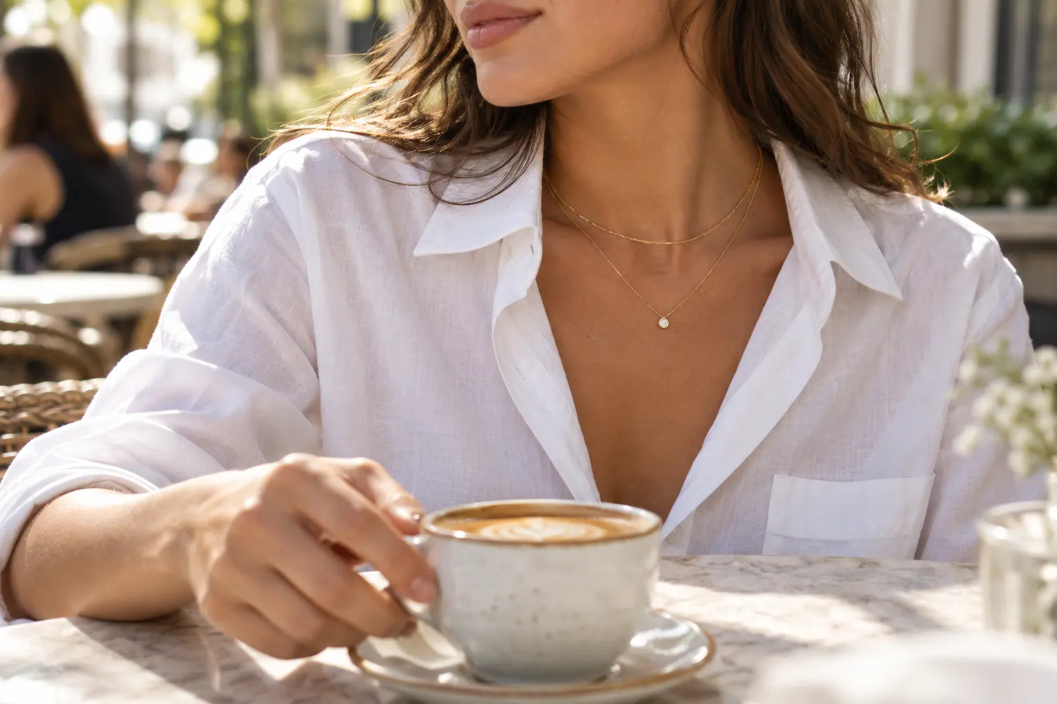 Two fine gold chains layered inside the open collar of a white shirt